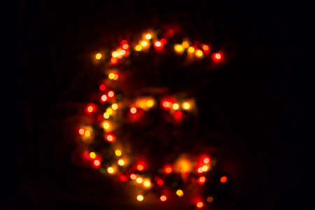 colorful letter E made of blurred circular bokeh on black backgroundの写真素材