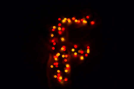 colorful letter F made of blurred circular bokeh on black backgroundの写真素材
