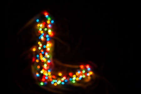 colorful letter L made of blurred circular bokeh on black backgroundの写真素材