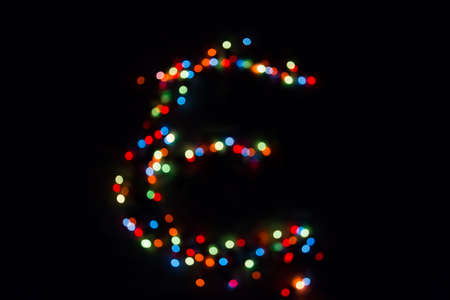 colorful letter E made of blurred circular bokeh on black backgroundの写真素材
