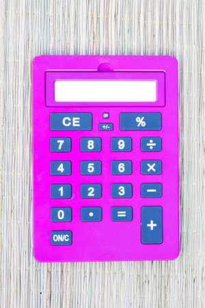 pink calculator on traditional mat with white space on the screenの写真素材