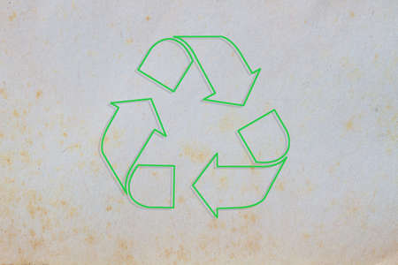 texture of old paper with yellow stain, background, with green sign of recycleの写真素材
