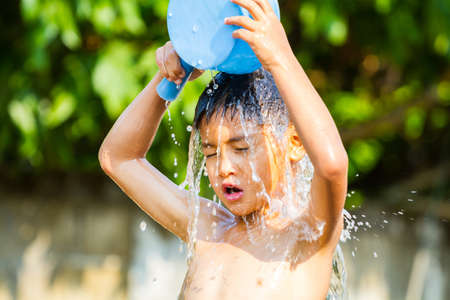 CHIANG RAI, THAILAND - APRIL 13 : Songkran festival, unidentified boy pouring water on his head in Songkran festival on April 13, 2015 in Chiang rai, Thailand.のeditorial素材