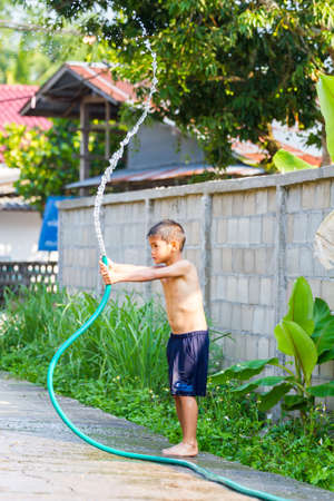 CHIANG RAI, THAILAND - APRIL 13 : Songkran festival, unidentified boy splashing water in Songkran festival on April 13, 2015 in Chiang rai, Thailand.のeditorial素材