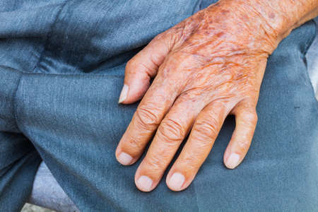 close up of elderly male hand on his lapの写真素材