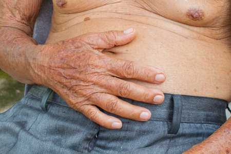 close-up old man with big belly has stomachacheの写真素材