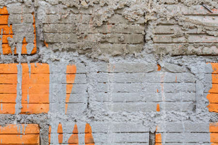 closeup orange horizontal textured brick with dry concrete stainの写真素材