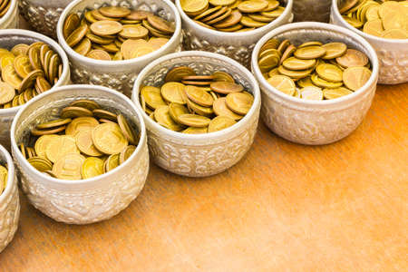 Coin in bowl for donation, temple of Thailand with copyspace.の写真素材