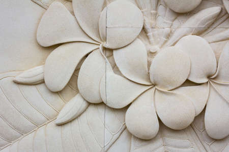 closeup Plumeria carved stone stone walls, background.の写真素材