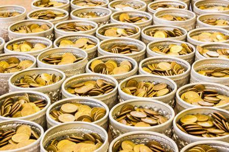 Coin in bowl for donation, temple of Thailand.の写真素材