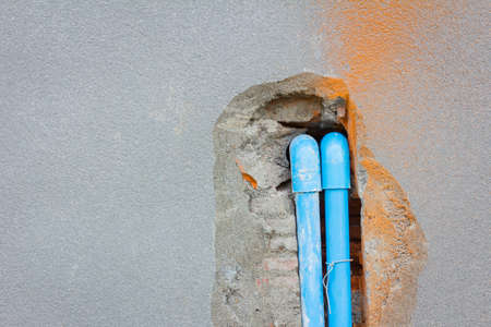 bury a pvc pipe in the concrete wall with copyspace on the left