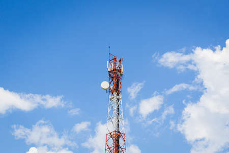 telecommunication tower in the middle of the picture with cloudy blue sky .