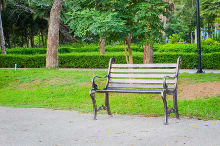 metal garden chair on concrete ground with green grass behindの写真素材
