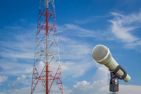 microphone on a stand with blurred telecommunication tower and cloudy  sky.の写真素材
