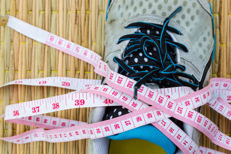 closeup running shoe with measuring tape, Health and Fitness Concept. Selective focus.