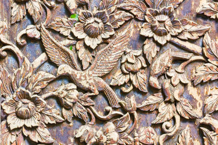 Carved bird and flowers on the wood background.の写真素材