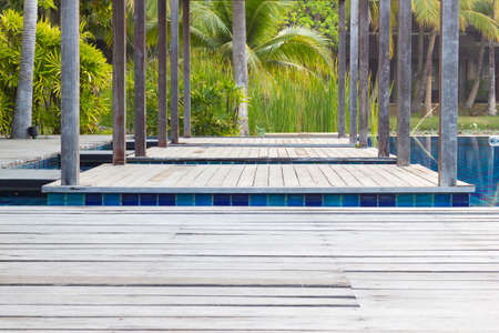 closeup swimming pool with stair and wooden deck, perspective view and coconut tree background.の写真素材