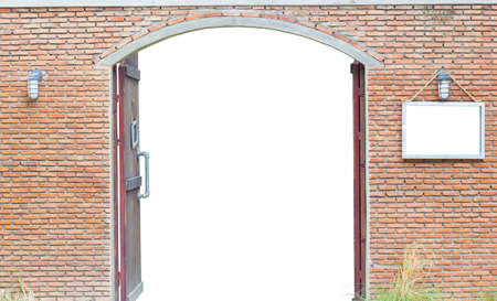 door in the ancient brick wall isolated on white background, clipping path, with blank space board on the right of the doorの写真素材