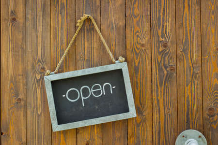 blackboard with the word open with rope on wooden door of a coffee shop.の写真素材