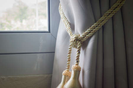 closeup curtains tassel with rope by the window on the left.の写真素材