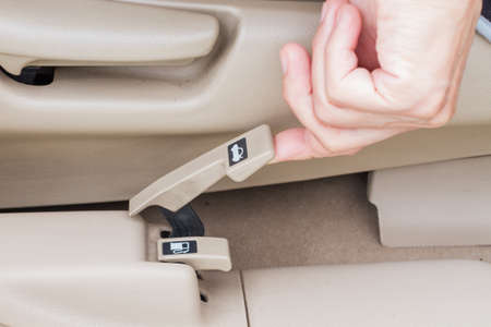 hand pulling trunk release button in a car. selective focus.の写真素材