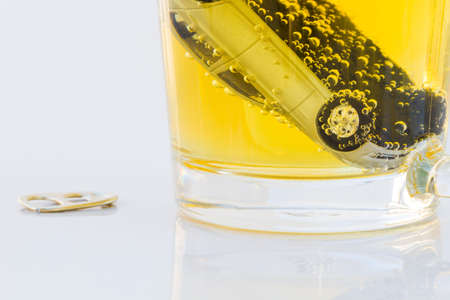 horizontal photo of toy car in a glass of beer isolated on white background. Drunk-driving Prevention Concept.の写真素材