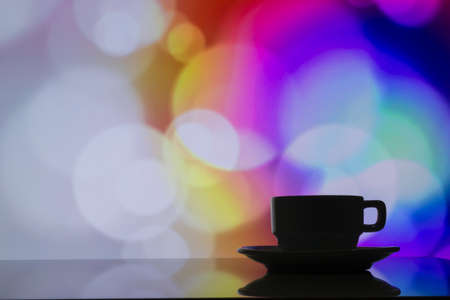 horizontal photo of silhouette coffee cup on colorful bokeh background.の写真素材