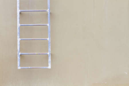 horizontal photo of blank wall background with old hanging ladder.の写真素材