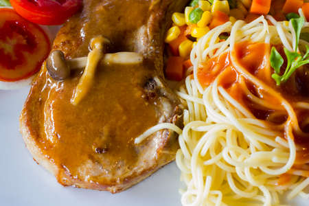 closeup spaghetti spicy sauce and t-bone steak on white dish.の写真素材