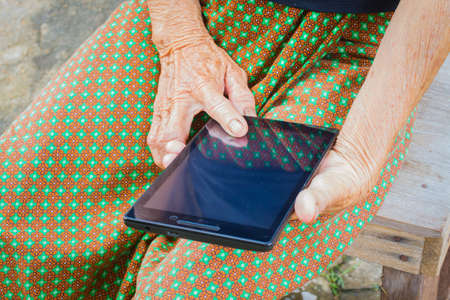 horizontal photo of closeup asian elder woman using tablet, technology concept.の写真素材