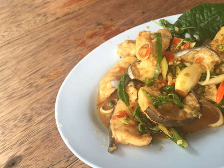 horizontal photo of fried spicy Mekong giant catfish with herb on wooden background, copyspaceの写真素材