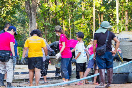 LAMPANG, THAILAND - NOVEMBER 5 : unidentified thai teenagers in working camp help villagers pouring concrete to make plaza on November 5, 2016 in Lampang, Thailandのeditorial素材