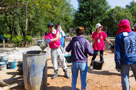 LAMPANG, THAILAND - NOVEMBER 5 : unidentified thai teenagers in working camp in line carrying water for mixing concrete to make plaza on November 5, 2016 in Lampang, Thailand.のeditorial素材