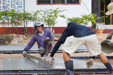 LAMPANG, THAILAND - NOVEMBER 5 : two unidentified thai workers leveling concrete with trowel on November 5, 2016 in Lampang, Thailand.のeditorial素材