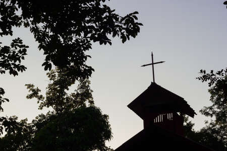 church roof with cross and tree background, silhouette photo.の写真素材