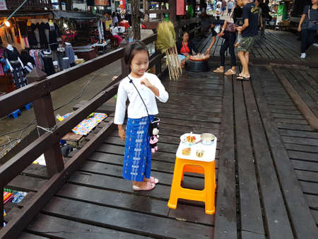KANCHANABURI, THAILAND - NOVEMBER 25: unidentified Burmese girl preparing thanaka powder for traveler at the old wooden Mon Bridge in Sangkhla Buri on November 25, 2016 in Kanchanaburi, Thailandのeditorial素材