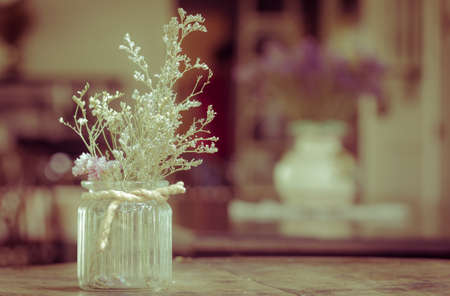 dry flowers in glass vase with rope on blurred background, copyspace. Vintage retro style.の写真素材