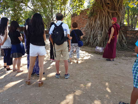 AYUTTHAYA, THAILAND - NOVEMBER 29: Unidentified tourists visit Buddha Head Statue in Banyan Tree in Wat Mahathat in the Ayutthaya Historical Park on November 29, 2016 in Ayutthaya, Thailandのeditorial素材