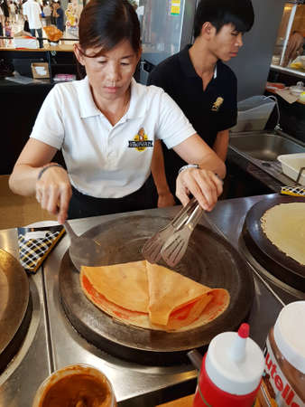 BANGKOK, THAILAND - NOVEMBER 30 : unidentified woman making crispy crape cake on stove in Tops Supermarket on November 30, 2016 in BANGKOK, Thailand.のeditorial素材