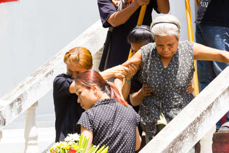 CHIANG RAI, THAILAND - APRIL 19 : unidentified asian old woman walking down the steps in thai traditional Christian funeral on April 19, 2017 in Chiang rai, Thailand.のeditorial素材