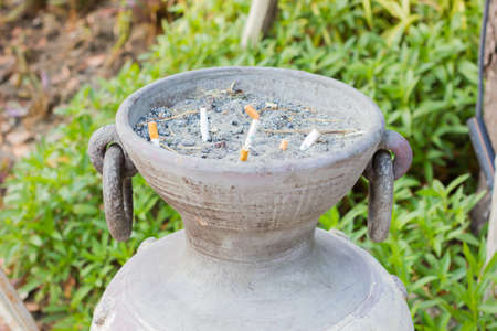 closeup smoked Cigarettes Butts in a public ashtray jarの写真素材