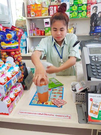 CHIANG RAI, THAILAND - MAY 8 : Unidentified female cashier working at the counter at a 7-Eleven shop...