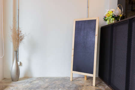 Blank restaurant menu blackboard on the wall with a vase and dry flowersの写真素材