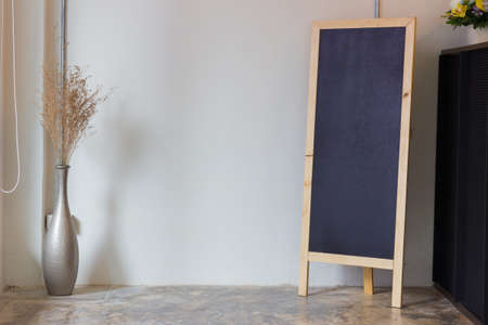 Blank restaurant menu blackboard on the wall with a vase and dry flowers
