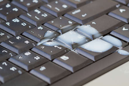 extreme close-up shot semen or sperm dropping on black Thai-English computer keyboard