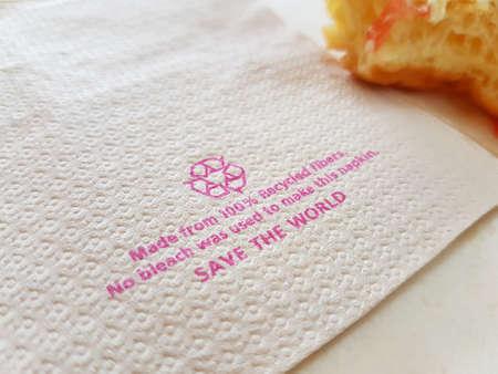 Brown tissue paper recycle on table with piece of donutの写真素材