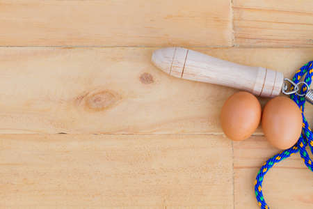 top view blue jump rope with two eggs on wooden bakcground, sex concept, copyspace for textの写真素材