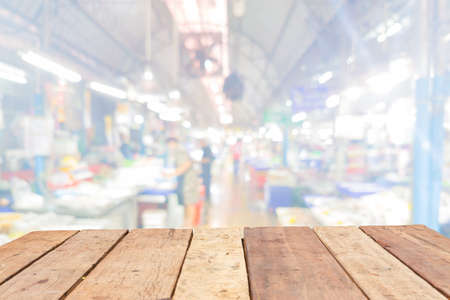 Wooden board empty table in front of blurred Thai fresh-food market background の写真素材