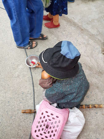 CHIANG MAI, THAILAND - SEPTEMBER 29 : Unidentified asian beggar sitting on the ground at street market in the evening on September 29, 2017 in Chiang Mai, Thailand.のeditorial素材