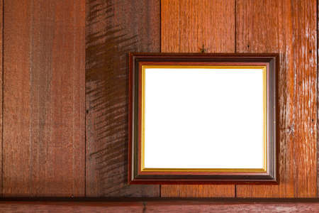 blank photo frame hanging on wooden wall background, copyspace. Clipping pathの写真素材